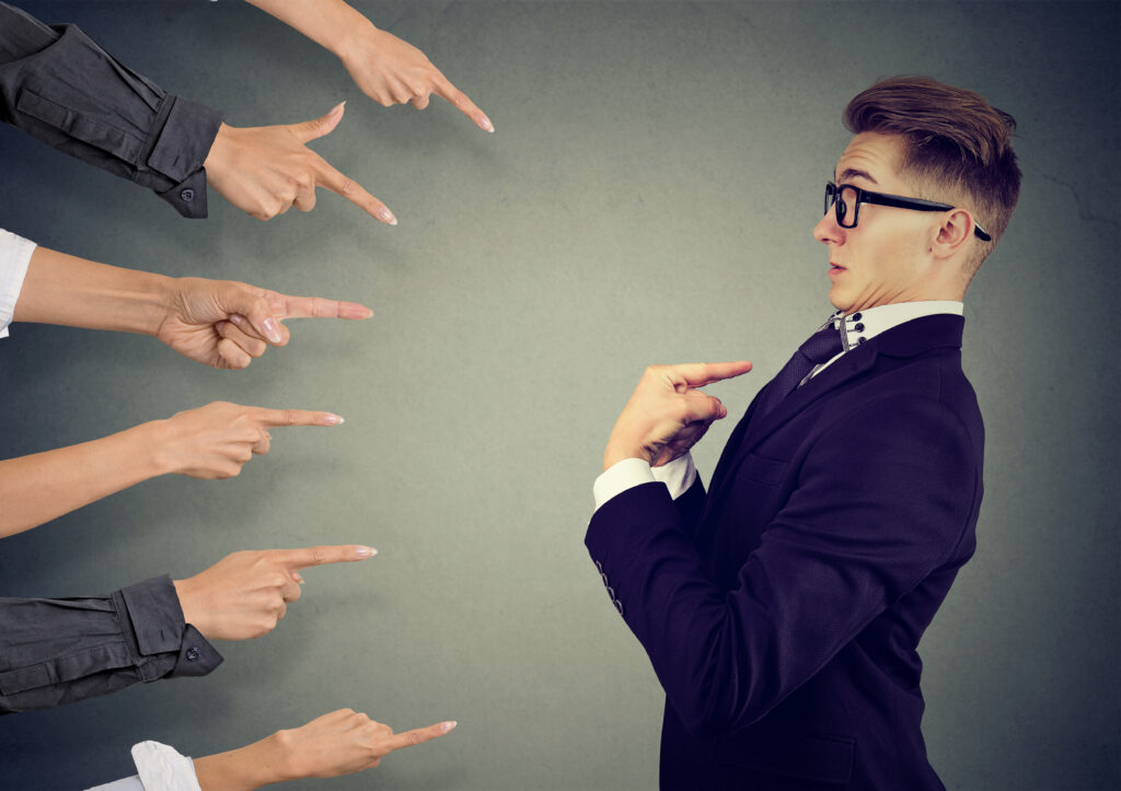 Anxious man judged by different people pointing fingers at him. Negative human emotions feeling